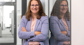 Eva Opitz lehnt an einer Glaswand und schaut in die Kamera. Foto: Frank Eppler / IW Medien